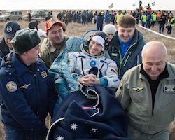 Astronaut being carried to the medical tent after landing